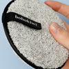 Close-up of Grey bohokiwi reusable makeup remover pad held in hand