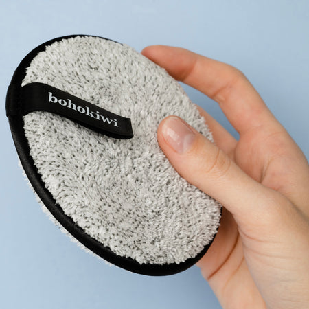 Grey reusable makeup remover pad showing bohokiwi finger strap
