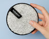 Grey bohokiwi reusable makeup remover pad shown in hand