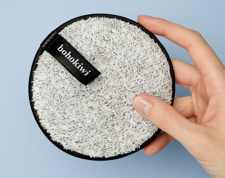 Grey bohokiwi reusable makeup remover pad shown in hand