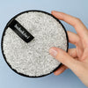Front view of Grey bohokiwi reusable makeup remover pad held in hand