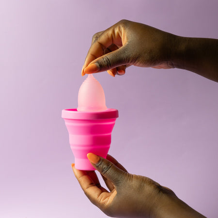Bohokiwi Hot Pink collapsible menstrual cup and disc steriliser being held open