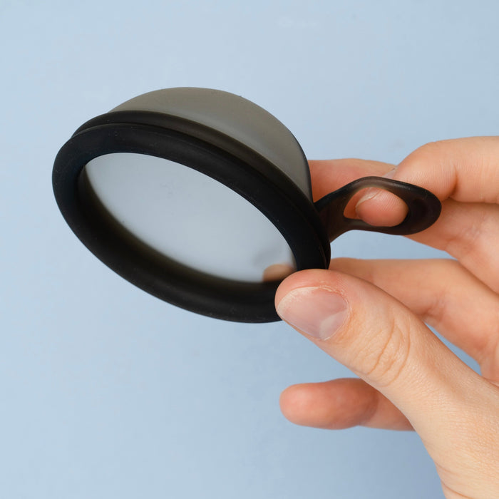 Bohokiwi Midnight Black reusable menstrual disc with removal ring held by hand