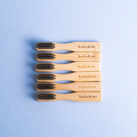 Six bohokiwi bamboo cleaning brushes arranged on a light blue background
