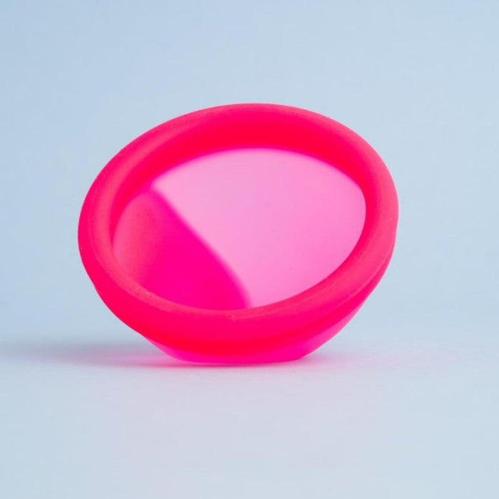 Close-up of Bohokiwi Neon Pink menstrual disc showing the flexible basin and rim